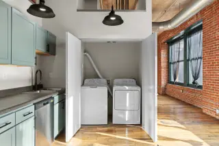 In-unit washer and dryer behind folding doors beside the kitchen