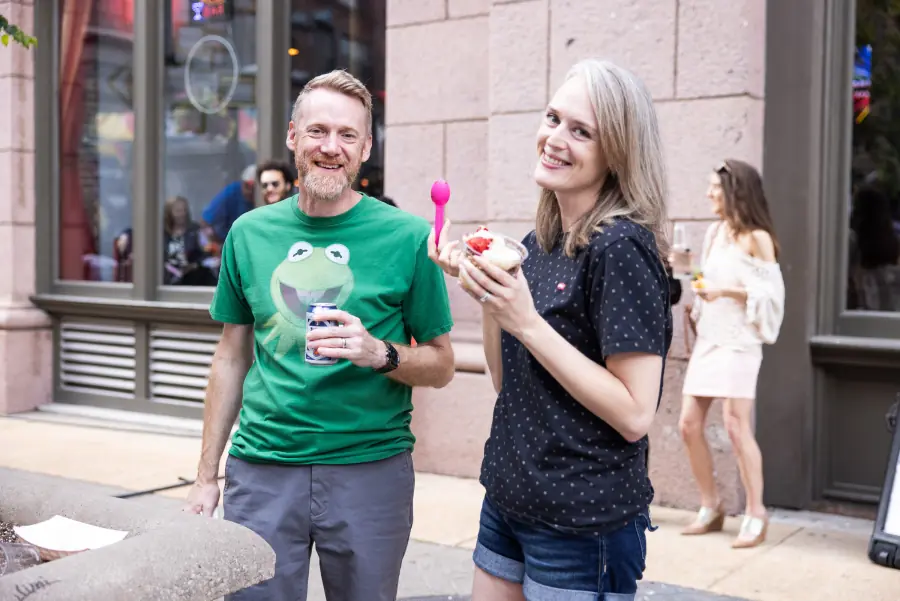 Two neighbors with drinks and dessert outside a Washington Avenue storefront